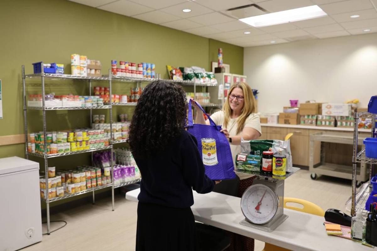 Food pantry worker helping student.